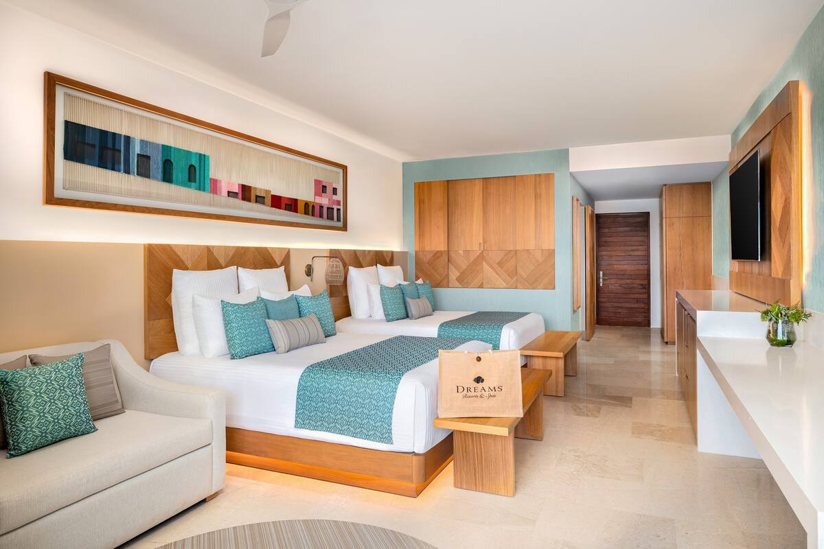 Une chambre d’hôtel moderne, dotée d’un grand lit, d’un canapé, d’un bureau et d’une télévision.