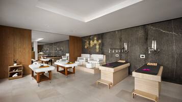 A modern spa with wooden and white furniture, a massage table, and a wall with a geometric design.