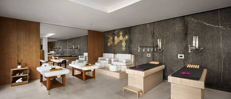 A modern spa with wooden and white furniture, a massage table, and a wall with a geometric design.