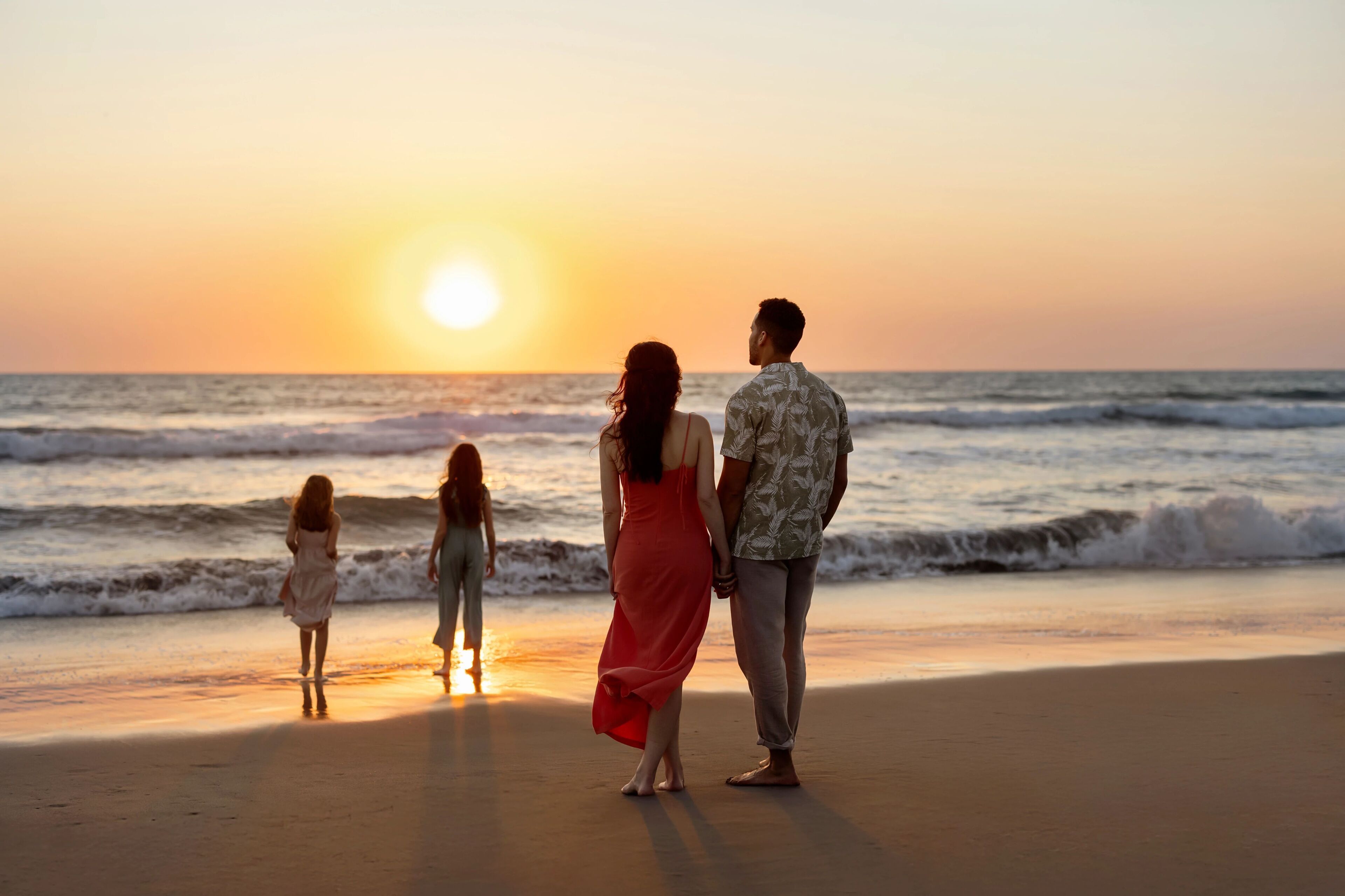 A sunset at the beach with a family.