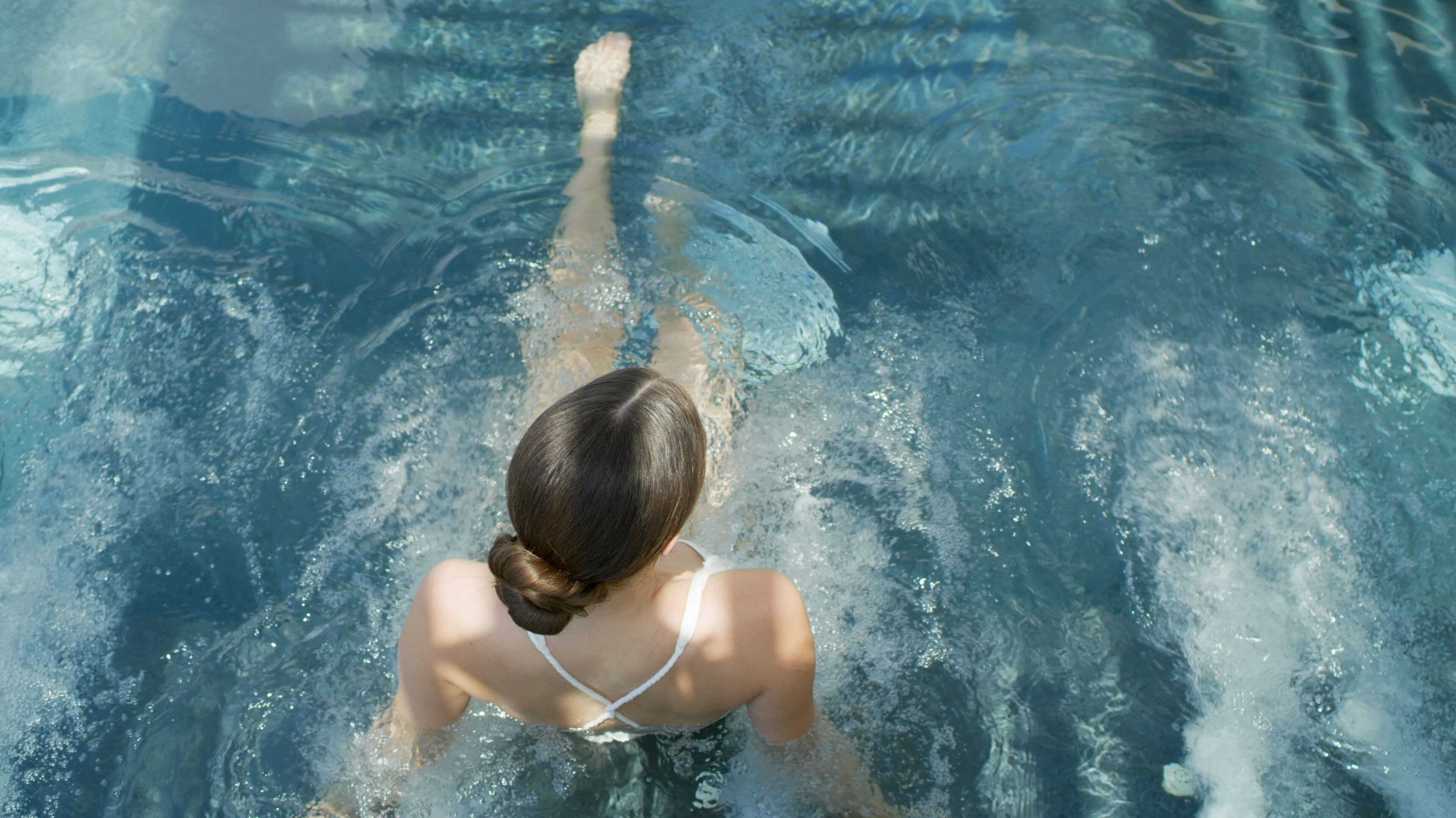 Uma pessoa nadando em uma piscina.