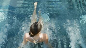 Uma pessoa nadando em uma piscina.