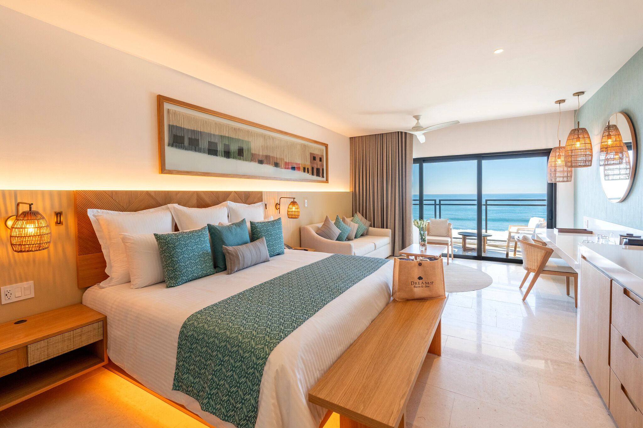 Una habitación de hotel moderna con una cama grande, un escritorio y vista al océano.
