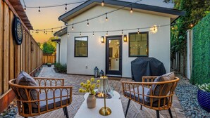 A patio with wicker chairs, a table, and a fire pit. - Modern 2-Bed Family Haven 🏡 Pet-Friendly + EV Charging 🐾⚡ (San Jose)