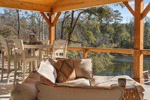 Una terraza de madera con un sofá, sillas y una mesa.