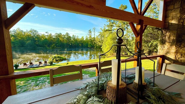 A wooden deck with a view of a lake and a boat dock.