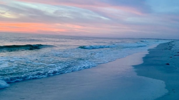 Une plage avec des vagues et un ciel dégagé.