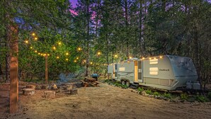 A campsite with a trailer labeled "Outback" and a picnic table. - River Retreat RV Campground ~ Gym / Game Room / Sauna (Jacksonville)