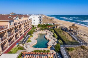 A hotel with a pool, beach access, and multiple balconies. - Afternoon Delight-Oceanfront Condo, Pet Friendly, Community Pools (Kill Devil Hills)