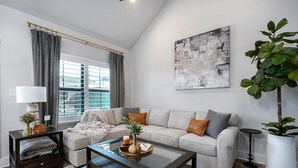 A modern living room with a sofa, coffee table, and decorative items.