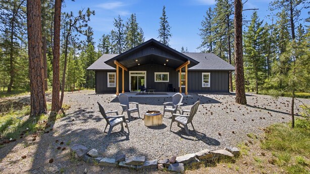 A cabin with a covered patio, surrounded by trees. - Clark Fork Crossing - Adventures You Seek in Western Montana.  River access.  (Superior)