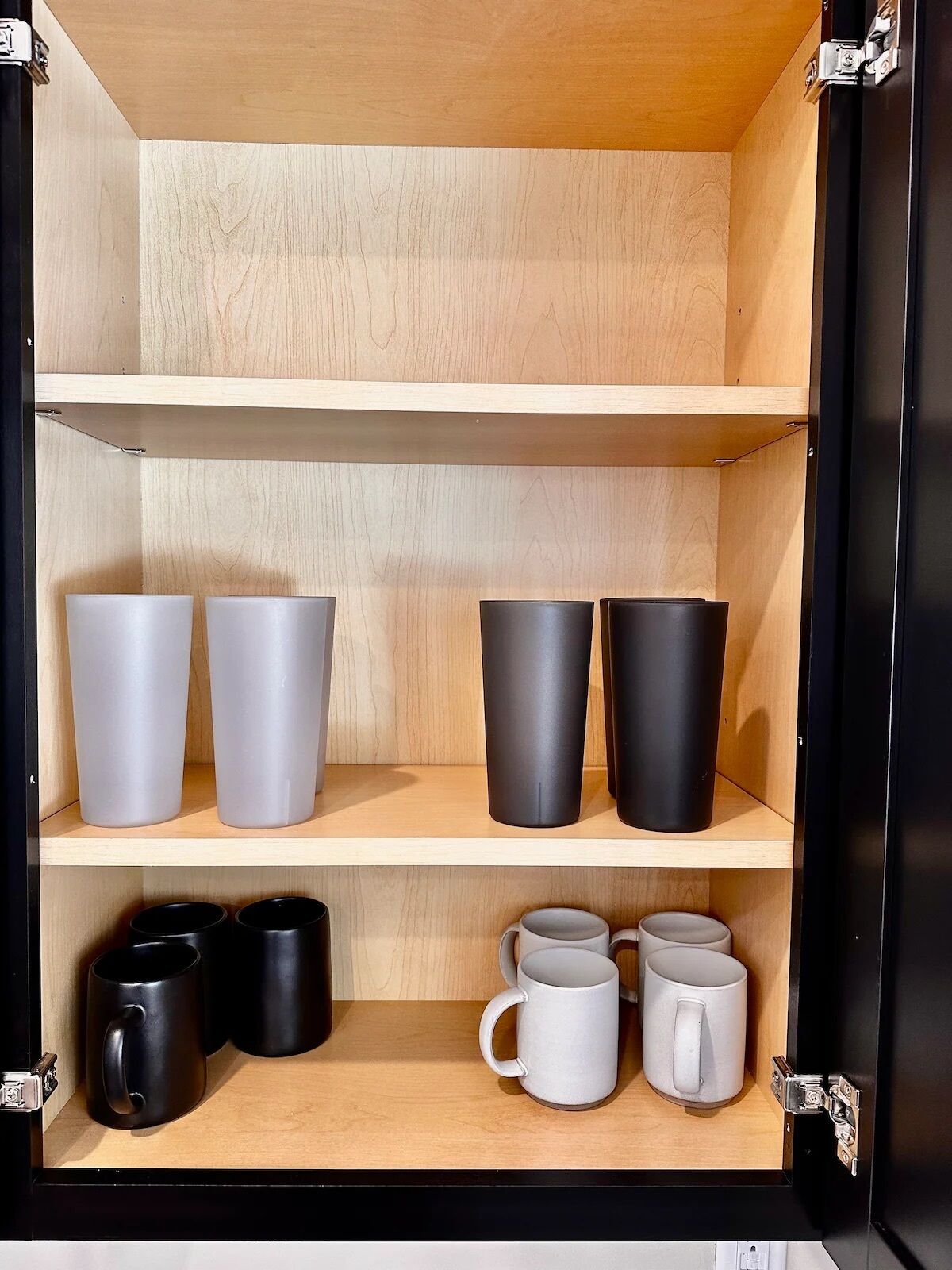 A storage unit with shelves holding various mugs and containers.
