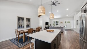 A modern kitchen with a central island, pendant lighting, and a built-in refrigerator. - Clark Fork Crossing - Adventures You Seek in Western Montana.  River access.  (Superior)