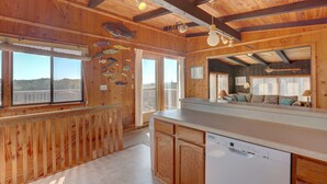 Un intérieur en bois comprenant un espace cuisine, des murs en bois et une grande fenêtre.