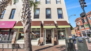 A building with a storefront named 'nourish' and a 'Macaron French Pastries' sign. - Modern Broughton Loft with Southern Charm (Savannah)