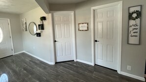 A hallway with two white doors, a mirror, and a framed sign on the wall. - Blue Mountain Retreat (Elgin)