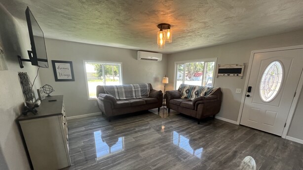 A spacious living room with two sofas, a coffee table, and a TV mounted on the wall. - Blue Mountain Retreat (Elgin)