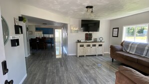 A spacious living area with a modern kitchen, a dining area, and a cozy seating area with a couch. - Blue Mountain Retreat (Elgin)
