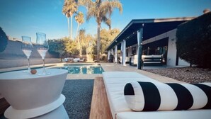 A poolside area with a white infinity pool, lounge chairs, and a modern outdoor seating area. - Scottsdale Oasis- Private Pool, King Bed, & Fire Table, 4bdrm (Scottsdale)
