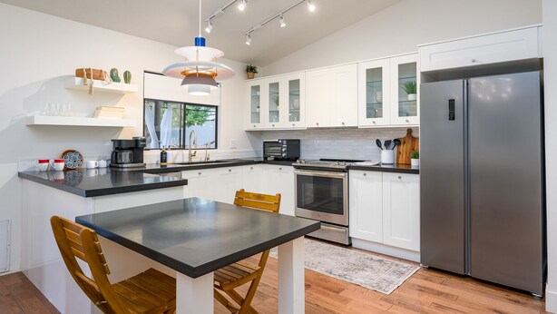 A modern kitchen with white cabinets, a stainless steel refrigerator, a built-in oven, and a coffee machine. - Scottsdale Oasis- Private Pool, King Bed, & Fire Table, 4bdrm (Scottsdale)
