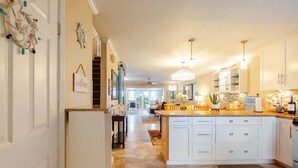 A spacious kitchen with a large island, white cabinetry, and a chandelier. - Your home away from home (Nassau)