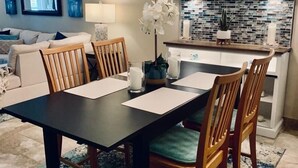 A dining area with a dark wooden table, six wooden chairs, and a chandelier. - Your home away from home (Nassau)