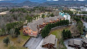 A lodge with multiple buildings, a parking lot, and a mountainous backdrop.