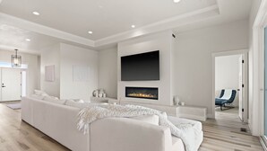 A modern living room with a white sofa, a fireplace, and a mounted TV. - Spokane Dream (Spokane County)
