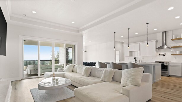 A spacious living room with a large white sofa, a round coffee table, and a view to the outside. - Spokane Dream (Spokane County)