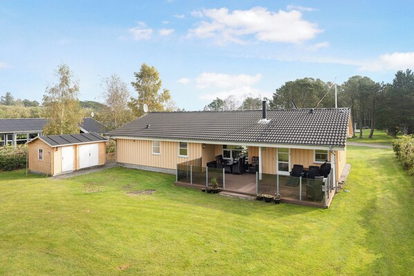A house with a covered patio, a garage, and a lawn.