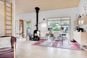 Ein modernes Interieur mit Essbereich, Kamin und Blick durch große Fenster.