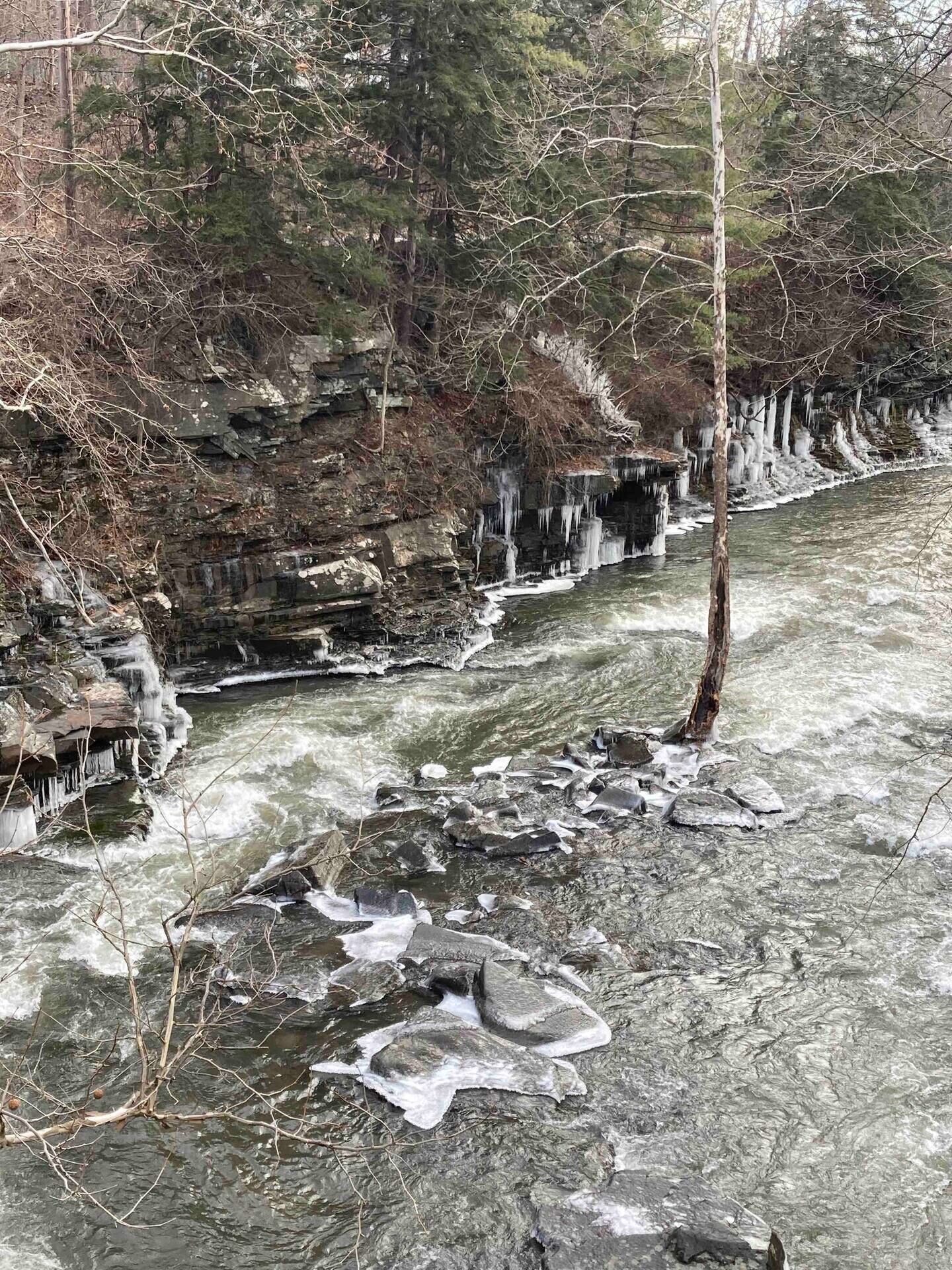A river with ice formations and rocky terrain.