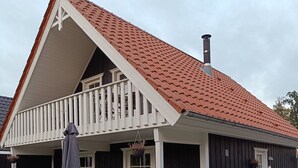 A house with a covered patio, a balcony, and a chimney. - Summer house for relaxation and activity (Gråsten)