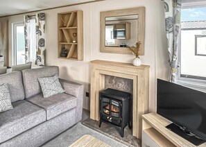 A living room with a sofa, fireplace, television, and a mirror. - This stunning holiday home with a double bedroom and en suite W. (Bishop Auckland)