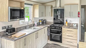A modern kitchen with a built-in microwave, stove, and sink.