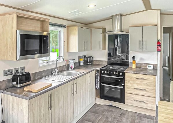 A modern kitchen with a built-in microwave, stove, and sink.