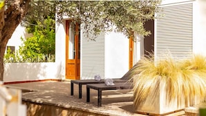 A patio area with a lounge chair, a small table, and a decorative plant. - Nice apartment near the beach in Port de Pollença (Port de Pollença)