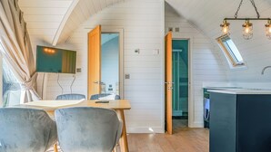 Een modern interieur met een eethoek, keuken en een tv aan de muur.