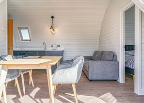 A compact living space with a dining area, kitchenette, and a cozy seating area.