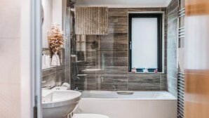 Een moderne badkamer met een bad, wastafel en toilet.