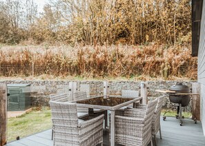 An outdoor patio with wicker furniture, a glass table, and a grill. - 2 bedroom accommodation in Bridgnorth (Bridgnorth)