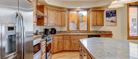 Una cocina moderna con armarios de madera, electrodomésticos de acero inoxidable y encimera de granito.