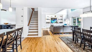 Ein modernes Interieur mit Treppe, Essbereich und Wohnraum.