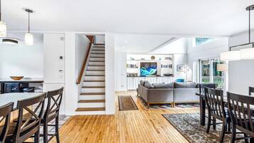 A modern interior with a staircase, dining area, and living space.