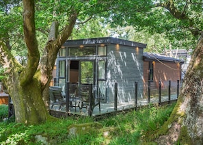 A modern cabin with large windows, a deck, and a rustic exterior. - 2 bedroom accommodation in Snowdonia (Snowdonia)