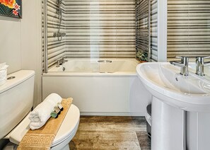 Un baño con inodoro, bañera y lavamanos.