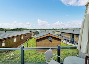 A residential area with multiple wooden houses, a grassy yard, and a clear sky.