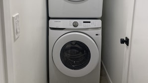 Et vaskerum med to stablede Samsung frontbetjente vaskemaskiner.