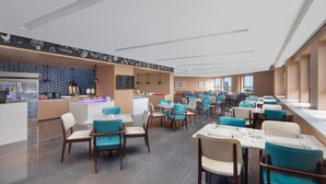 Un restaurante moderno con una barra central, varias mesas para comer con sillas y una pared con diseño de espiga.