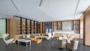 Un interior moderno con una zona de estar, una cocina y una estantería.